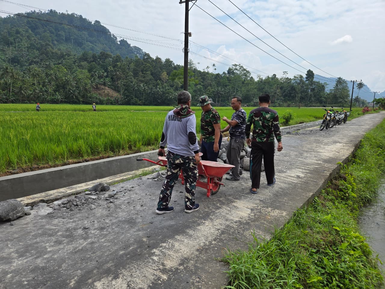Suara Batu yang jatuh berpadu dengan tawa warga terdengar akrab di Dusun Krajan II, Desa Lebakharjo, Kecamatan Ampelgading. Di bawah teriknya matahari, personel Satuan Angkatan Laut (TNI AL) bersama Kodim 0818/Malang-Batu dan masyarakat setempat bahu-membahu melanjutkan pekerjaan saluran irigasi dalam program TMMD ke-126.