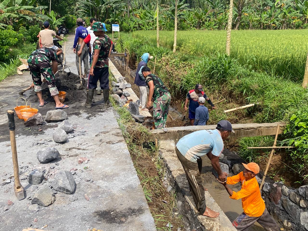 Anggota Satgas TNI Manunggal Membangun Desa (TMMD) ke-126 Kodim 0818/Malang-Batu terus menunjukkan dedikasi tinggi dalam melaksanakan pekerjaan peningkatan saluran irigasi di Desa Lebakharjo, Kecamatan Ampelgading, Kabupaten Malang. Kegiatan ini merupakan salah satu sasaran fisik utama dalam program TMMD yang bertujuan untuk meningkatkan kesejahteraan masyarakat melalui pembangunan infrastruktur pertanian.