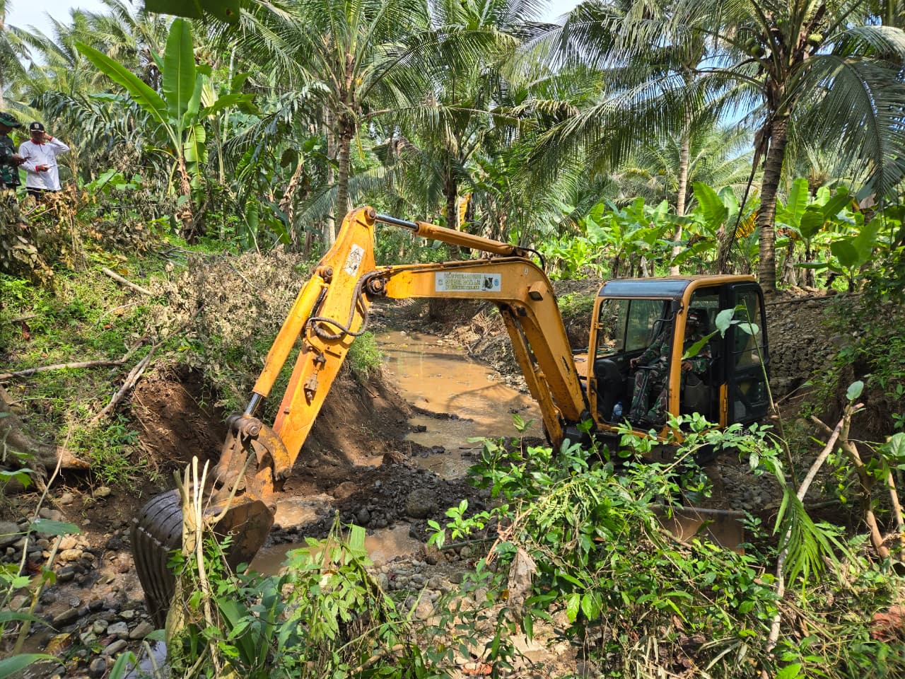 Program TNI Manunggal Membangun Desa (TMMD) ke-126 Kodim 0818/Malang-Batu terus menunjukkan progres signifikan. Salah satu kegiatan fisik yang menjadi prioritas adalah normalisasi saluran irigasi di Dusun Lebaksari, Desa Lebakharjo, Kecamatan Ampelgading. Kegiatan ini dilaksanakan oleh Satuan Yonarmed 8/UY, yang hingga kini telah mencapai 96 persen penyelesaian pekerjaan menggunakan alat berat.