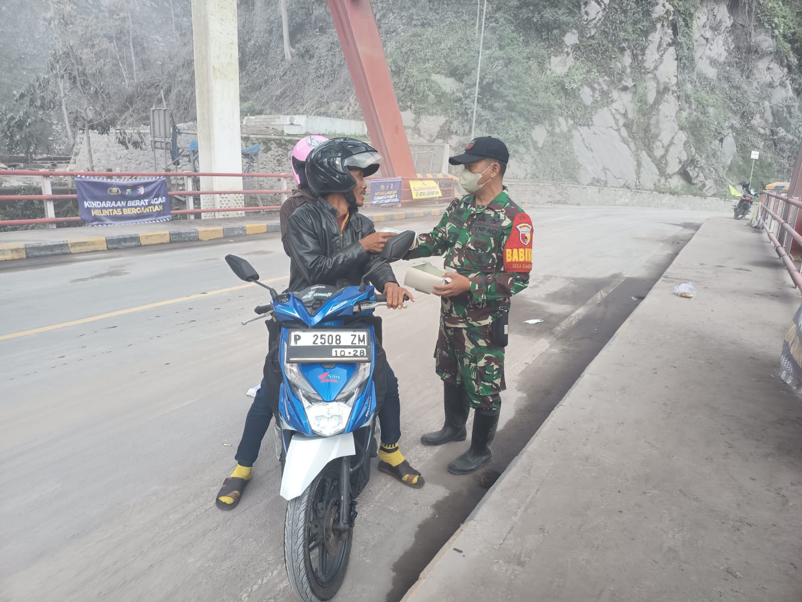 Babinsa Sumberwuluh Amankan Lalin dan Lindungi Pengendara dengan Pembagian Masker.